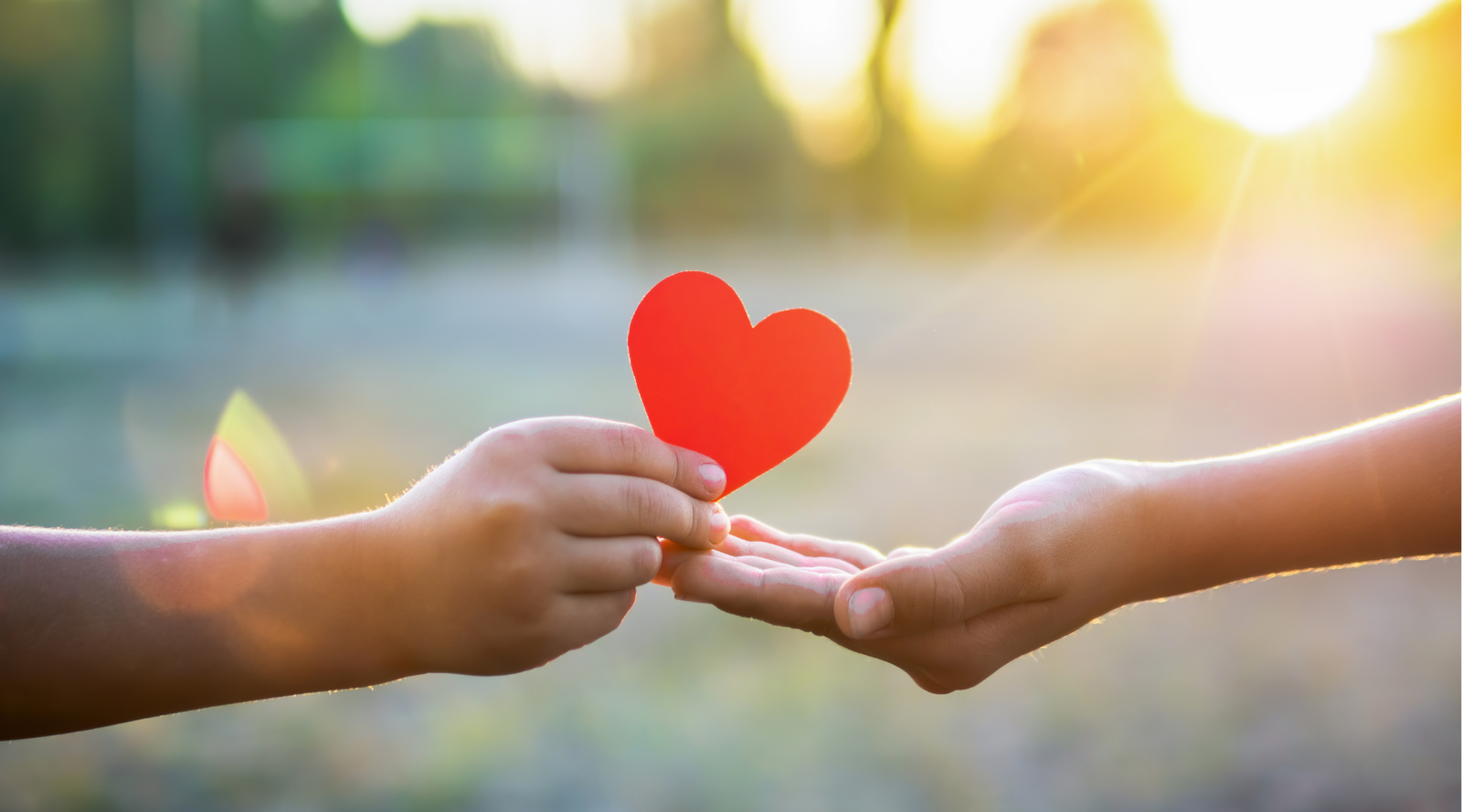 eco-friendly valentines for kids: two hands reaching together to exchange a red paper heart