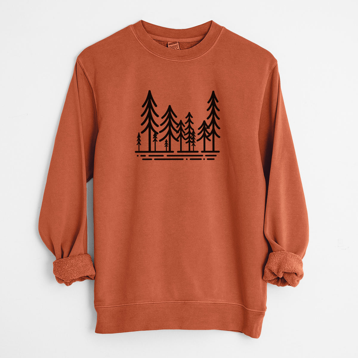 Amber orange pigment dyed crewneck sweatshirt laid flat with the sleeves rolled, printed with bold black line art of ten simple pine trees above horizontal lines.