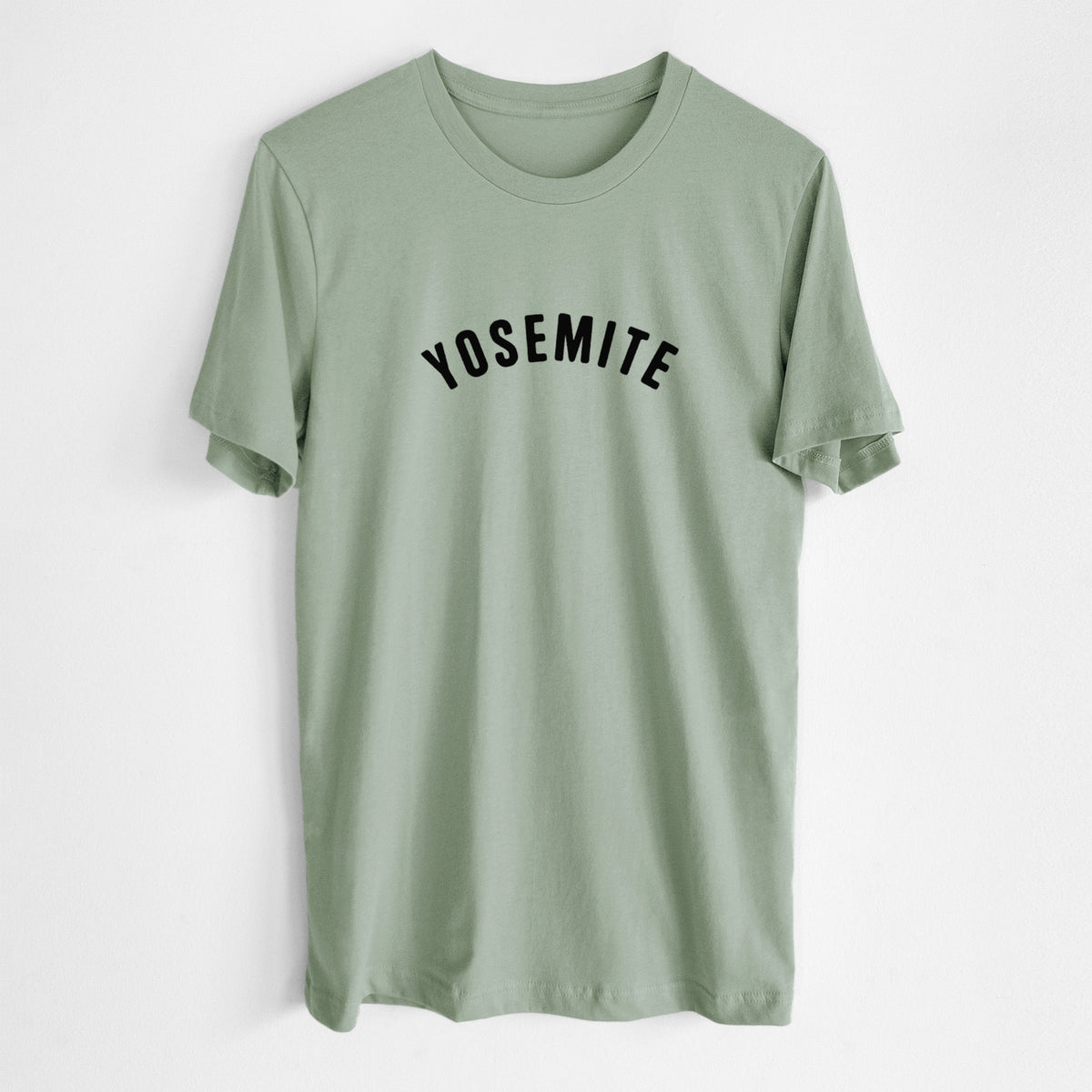 Sage green lightweight cotton t-shirt laid flat, printed with the word Yosemite in bold black letters arched across the chest.