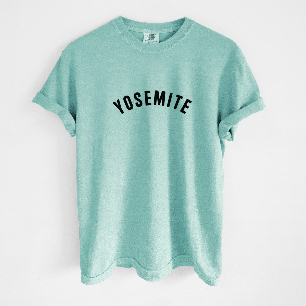 Chalky mint Comfort Colors t-shirt laid flat, printed with the word Yosemite in bold black letters arched across the chest.
