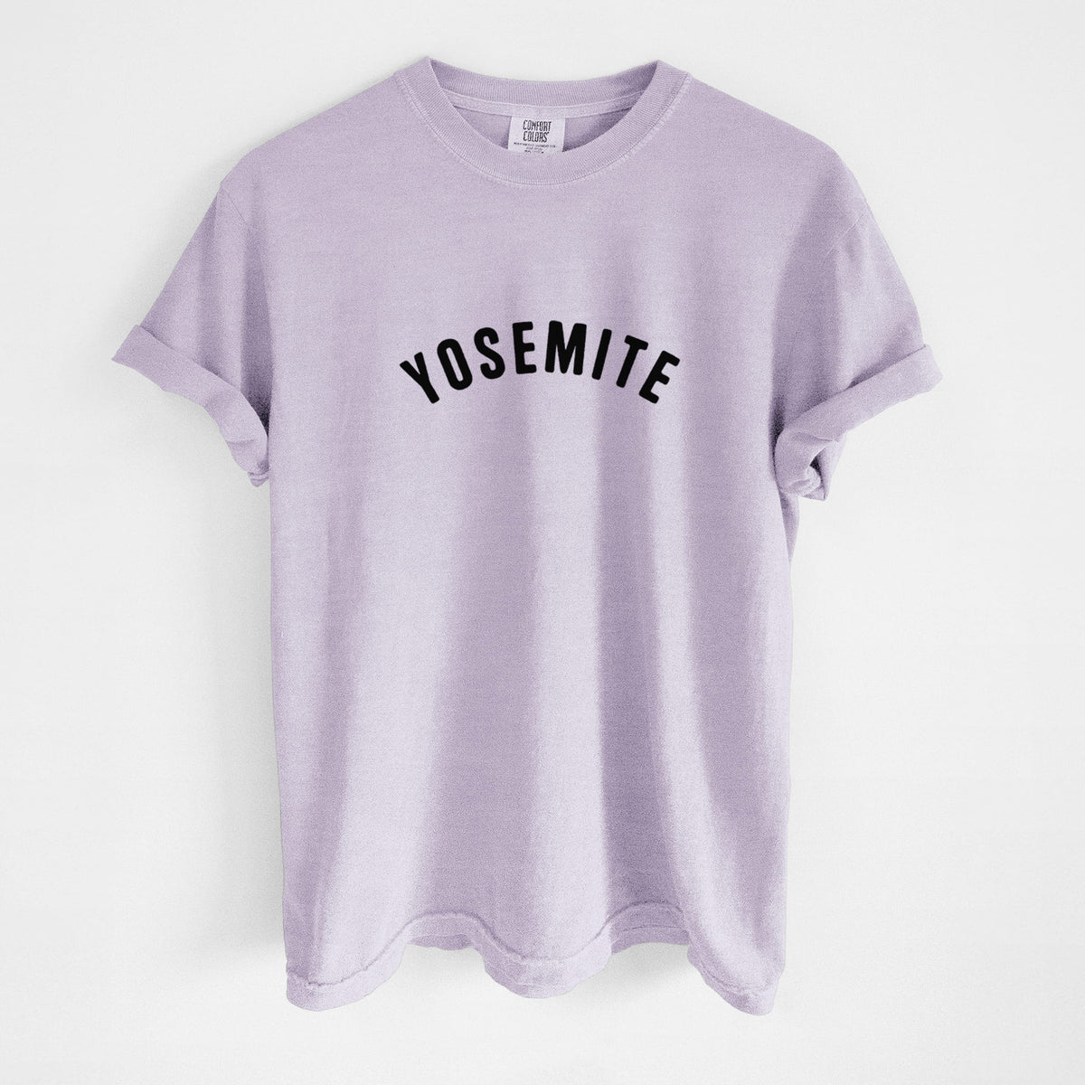Orchid purple Comfort Colors t-shirt laid flat, printed with the word Yosemite in bold black letters arched across the chest.