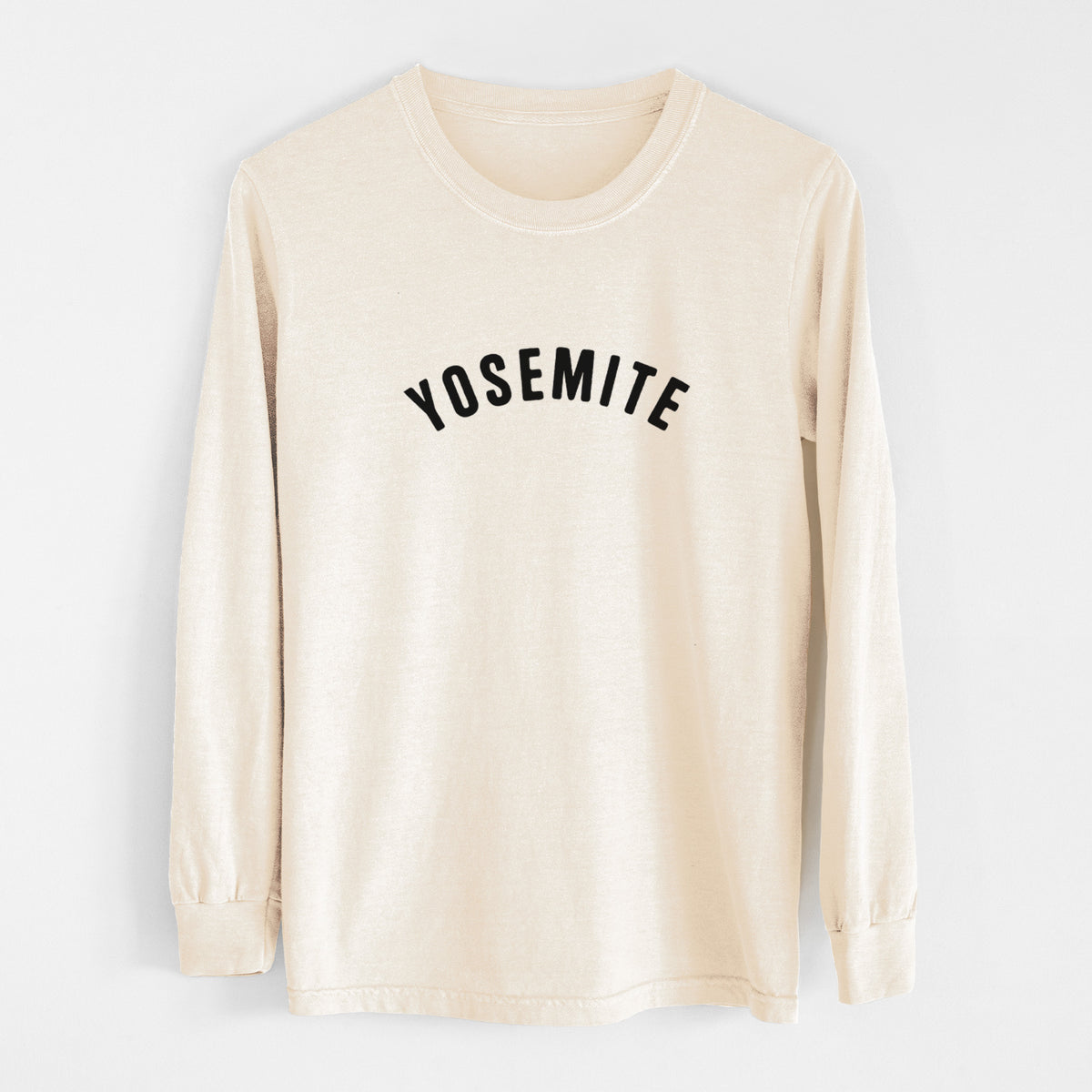 Ivory Comfort Colors long sleeve shirt laid flat, printed with the word Yosemite in bold black letters arched across the chest.