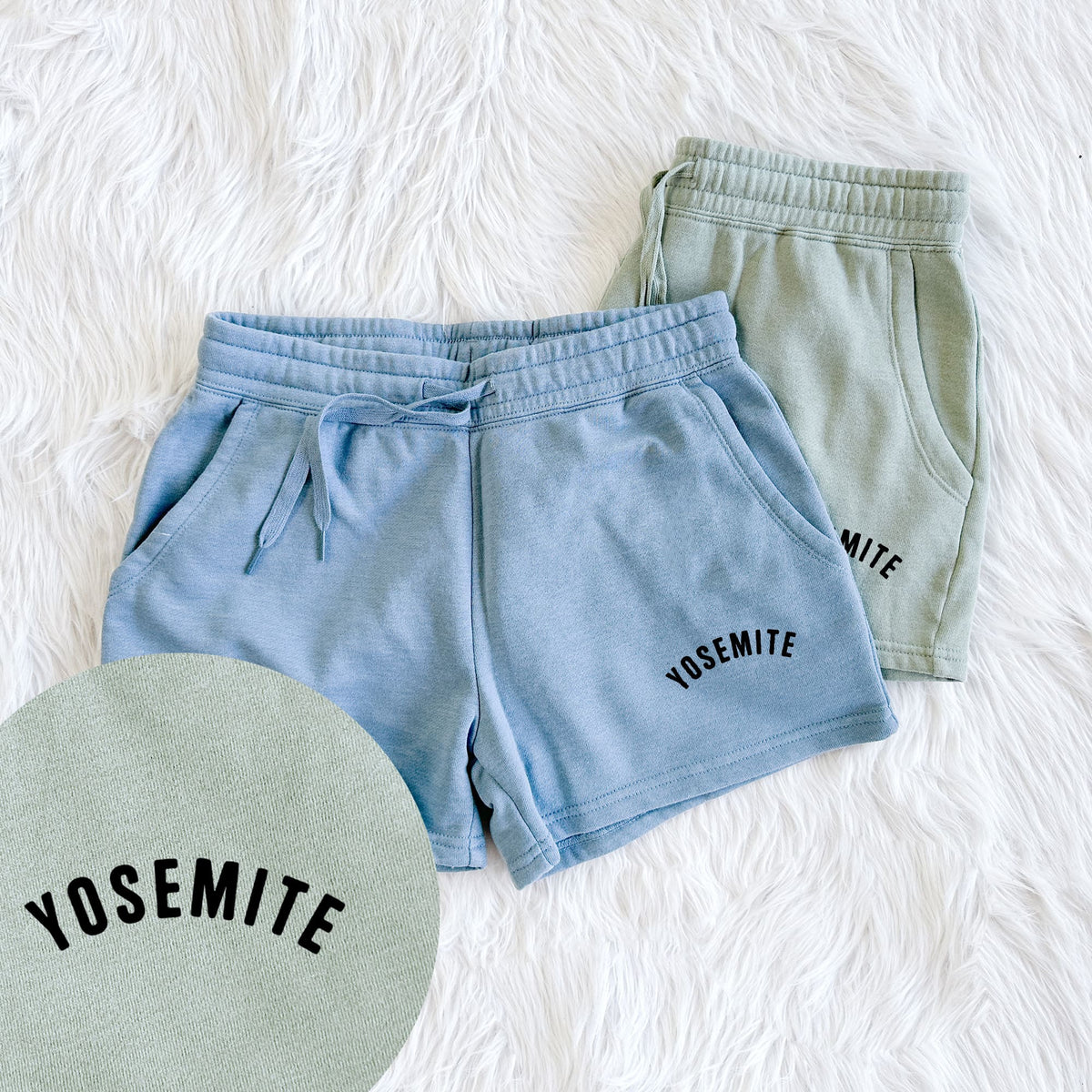 Two pairs of Cali Wave shorts in different colors printed with the word Yosemite in bold black letters arched across the chest, with a close-up of the print.