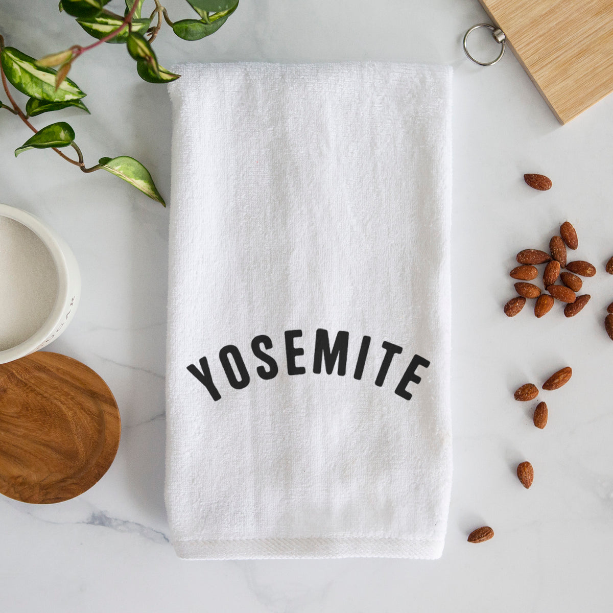 White hand towel printed with the word Yosemite in bold black letters arched across the chest.