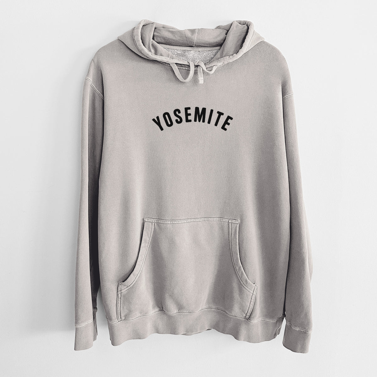 Cement grey pigment dyed hoodie laid flat, printed with the word Yosemite in bold black letters arched across the chest.