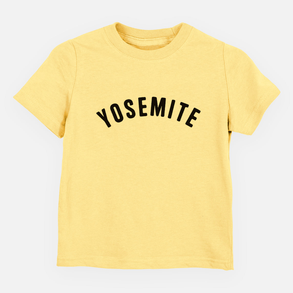 Butter yellow toddler t-shirt laid flat, printed with the word Yosemite in bold black letters arched across the chest.