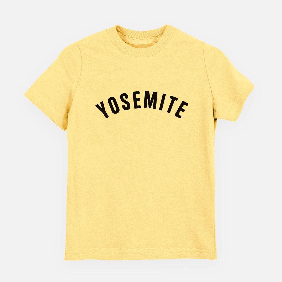 Butter yellow youth t-shirt laid flat, printed with the word Yosemite in bold black letters arched across the chest.