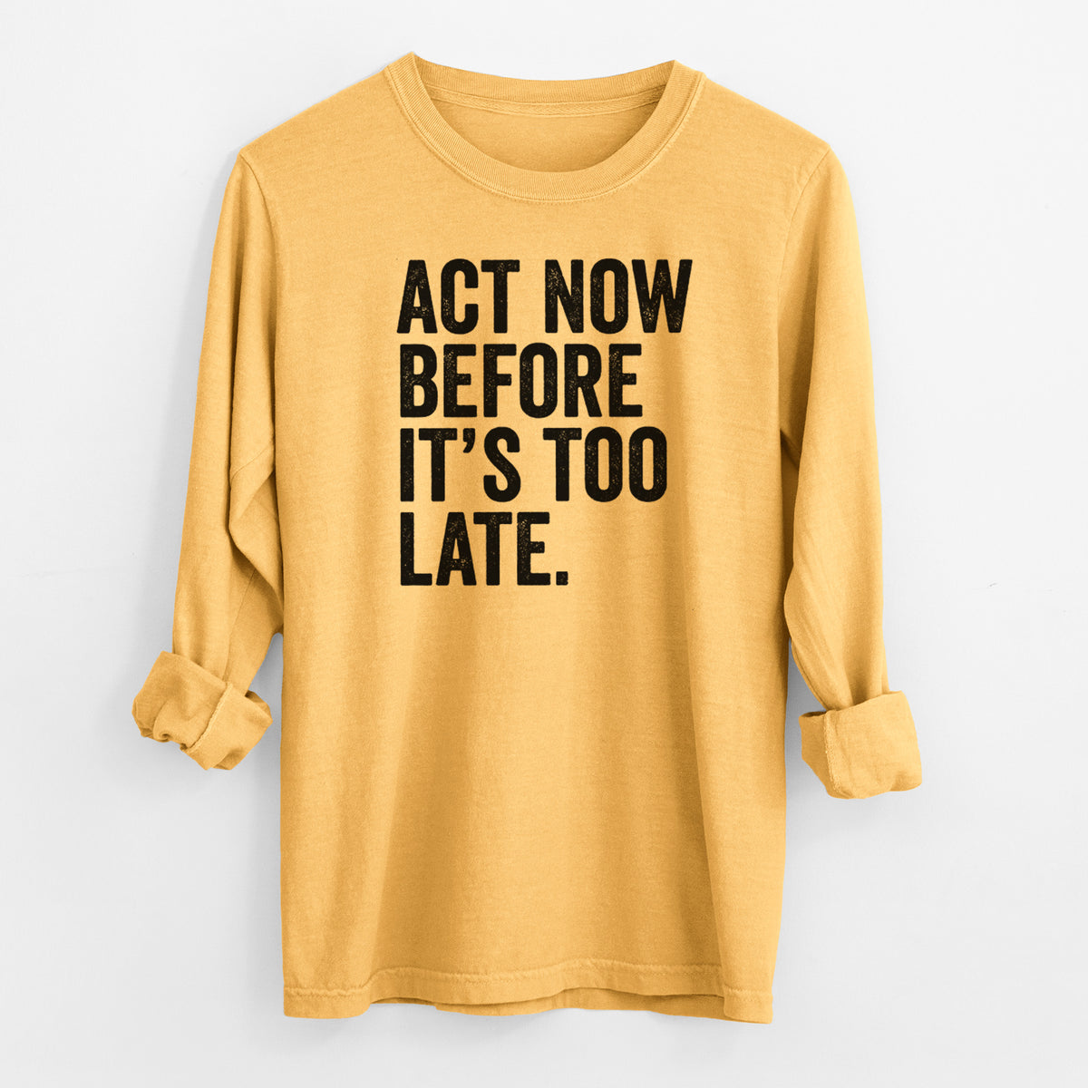 Golden wheat yellow Comfort Colors long sleeve shirt laid flat with the cuffs rolled, printed with bold black words reading Act Now Before It's Too Late.
