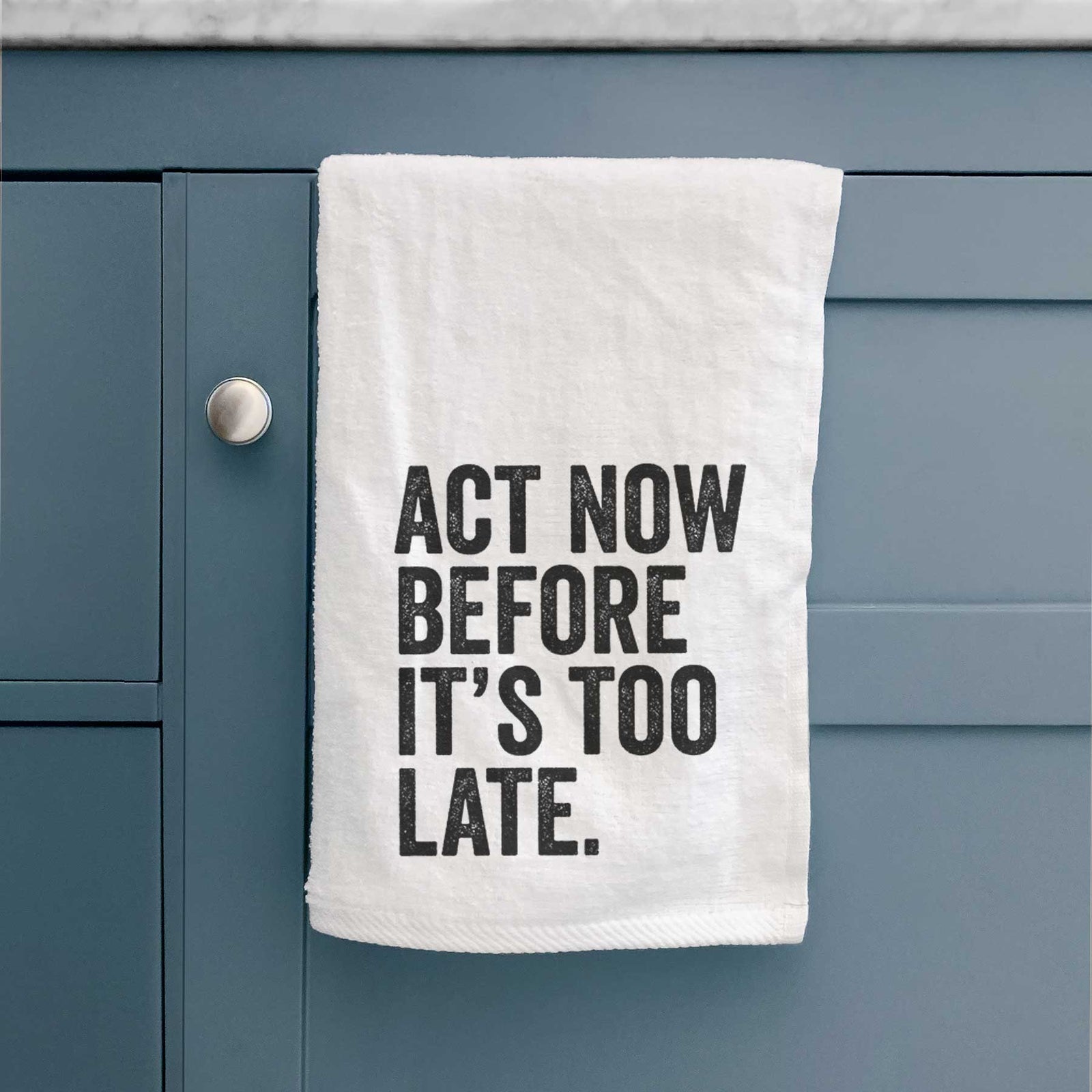 White hand towel printed with bold black words reading Act Now Before It's Too Late.