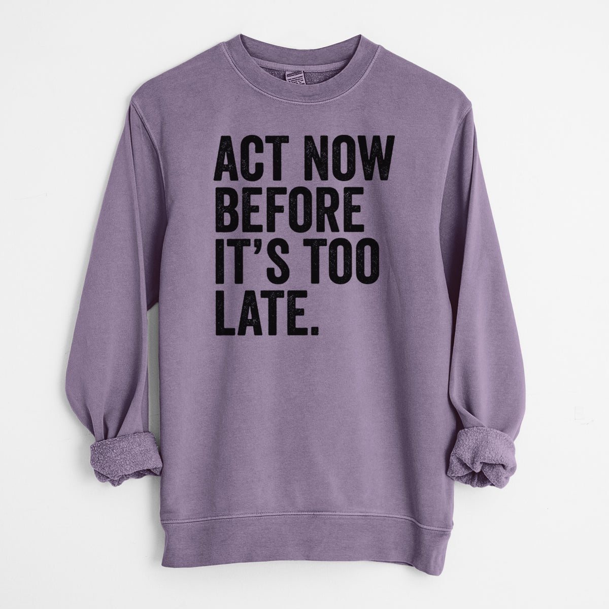 Plum purple pigment dyed crewneck sweatshirt laid flat with the sleeves rolled, printed with bold black words reading Act Now Before It's Too Late.