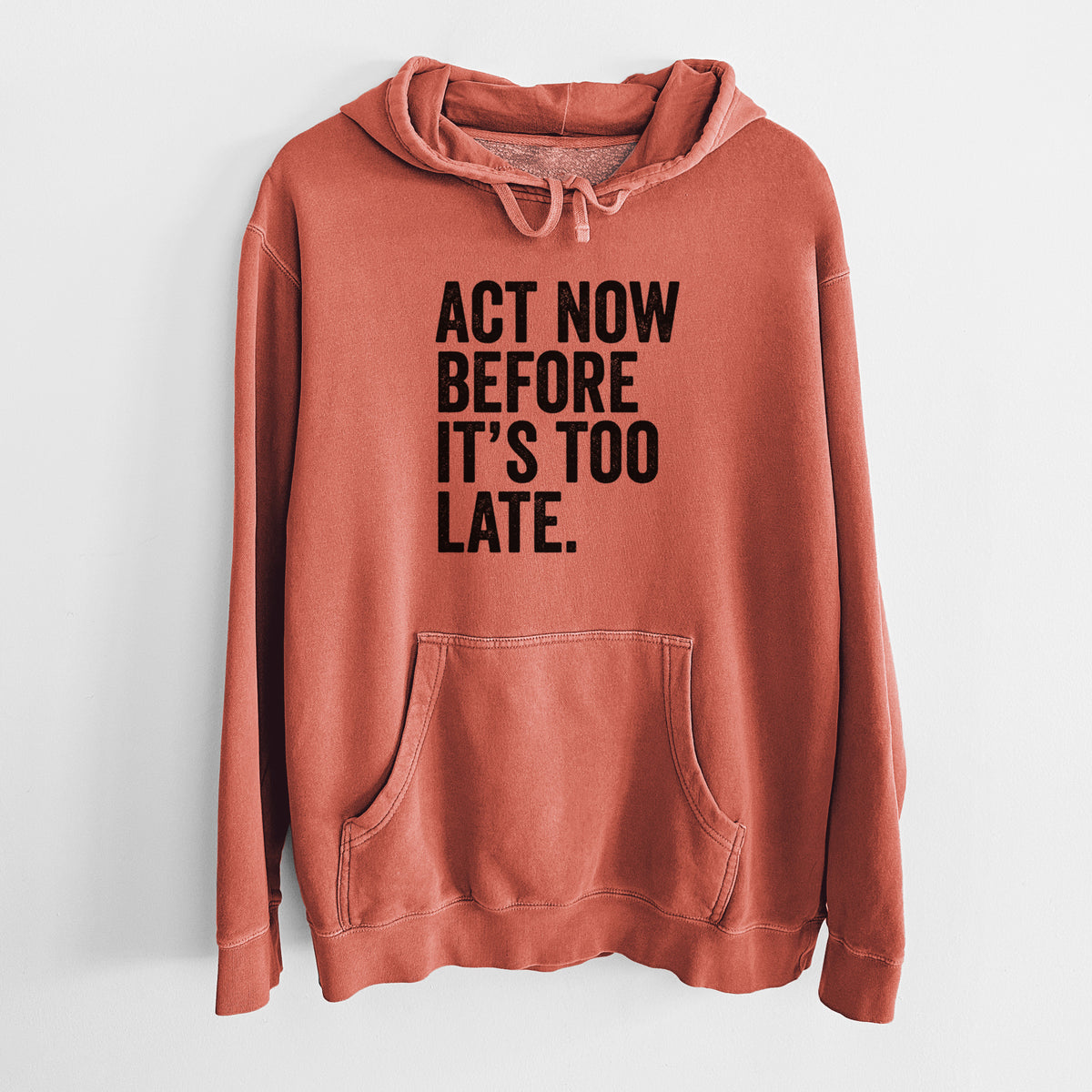 Amber orange pigment dyed hoodie laid flat, printed with bold black words reading Act Now Before It's Too Late.