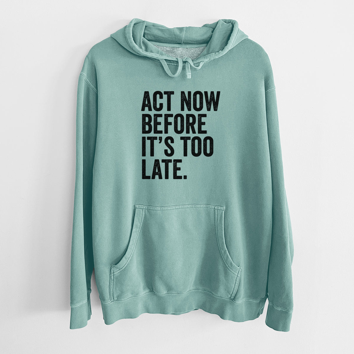 Mint green pigment dyed hoodie laid flat, printed with bold black words reading Act Now Before It's Too Late.