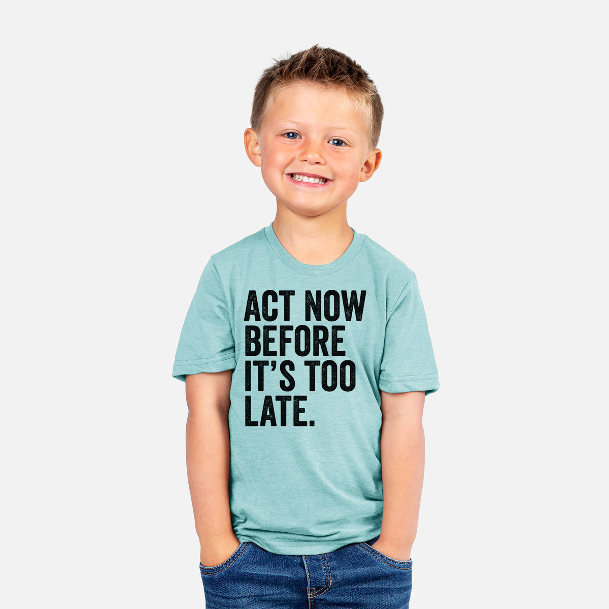 Smiling boy wearing a youth t-shirt printed with bold black words reading Act Now Before It's Too Late.