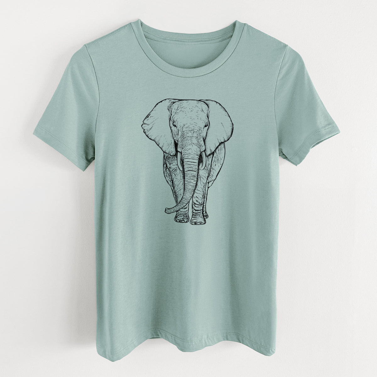 Dusty blue women's relaxed fit cotton t-shirt laid flat, printed with a black ink line drawing of an African elephant facing forward with large ears and tusks.