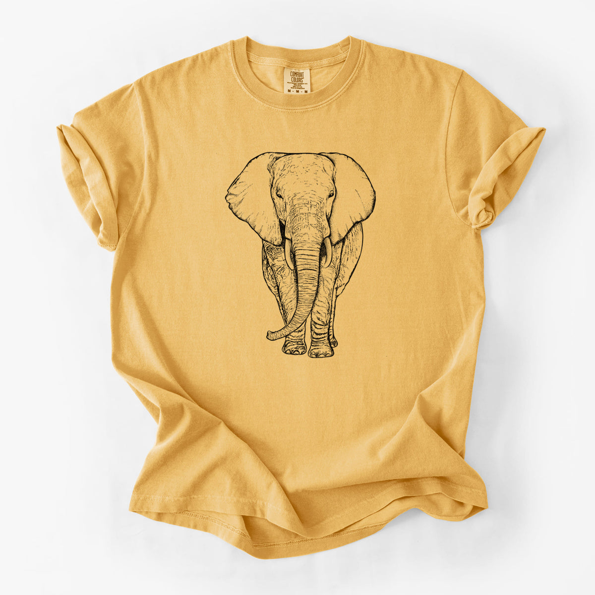 Golden wheat yellow Comfort Colors t-shirt laid flat, printed with a black ink line drawing of an African elephant facing forward with large ears and tusks.