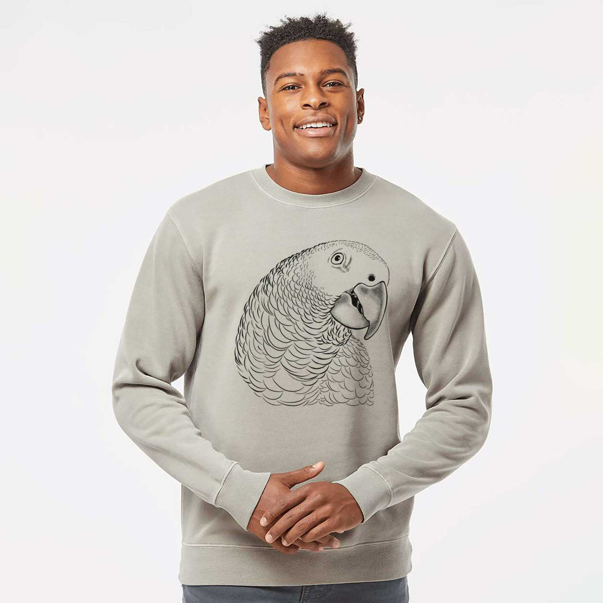 Model wearing a cement grey pigment dyed crewneck sweatshirt printed with a detailed black ink portrait of an African grey parrot's head.