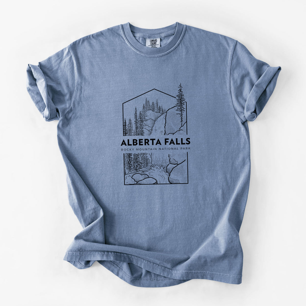 Blue jean Comfort Colors t-shirt laid flat, printed with a black line art badge of Alberta Falls with pine trees, with the words Alberta Falls, Rocky Mountain National Park.
