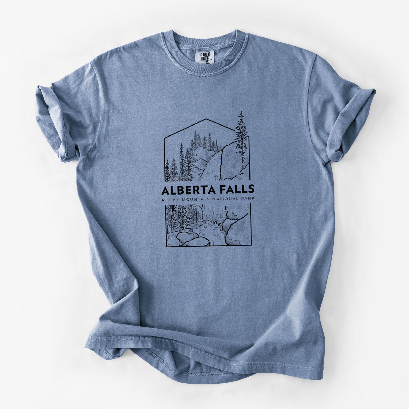 Blue jean Comfort Colors t-shirt laid flat, printed with a black line art badge of Alberta Falls with pine trees, with the words Alberta Falls, Rocky Mountain National Park.