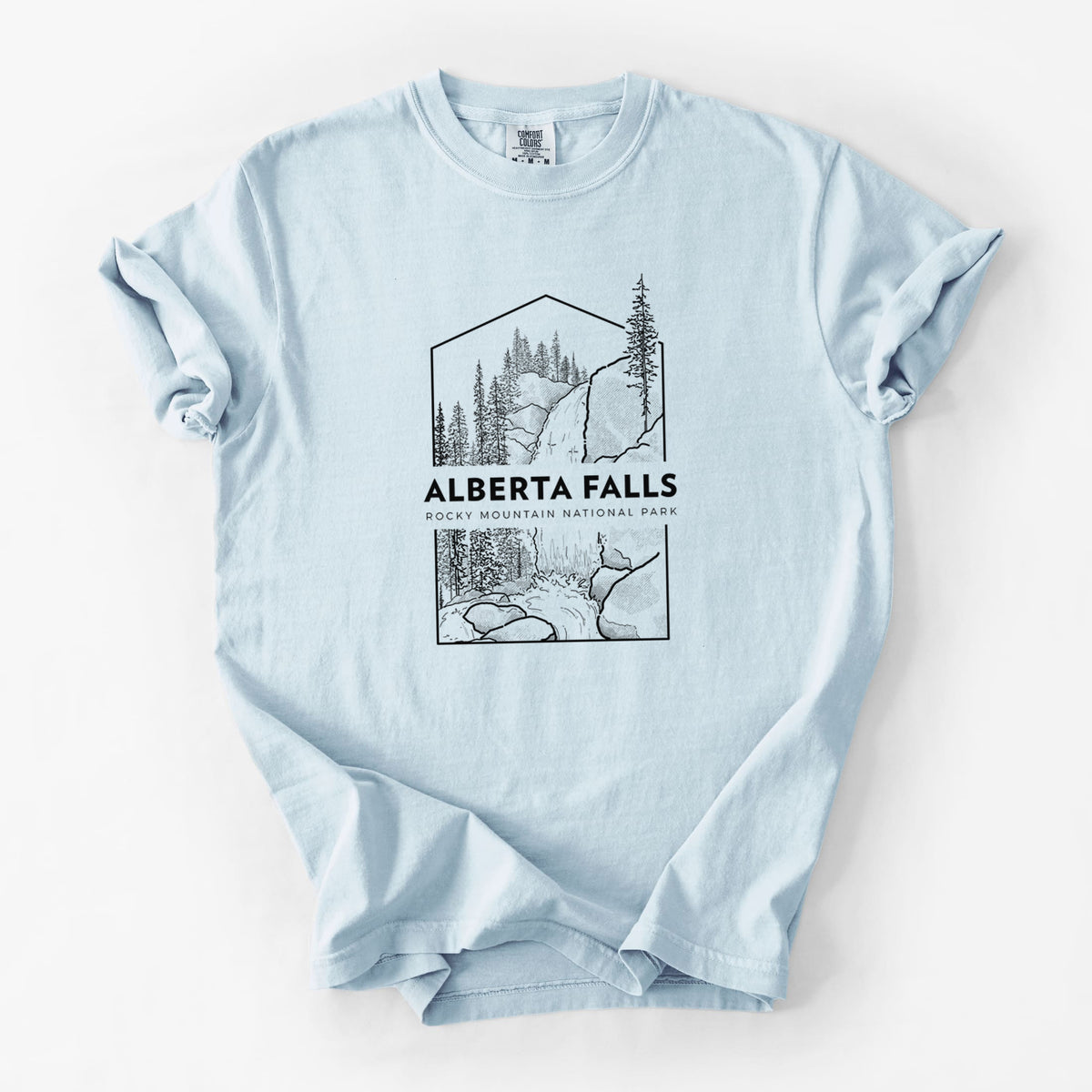 Chambray blue Comfort Colors t-shirt laid flat, printed with a black line art badge of Alberta Falls with pine trees, with the words Alberta Falls, Rocky Mountain National Park.