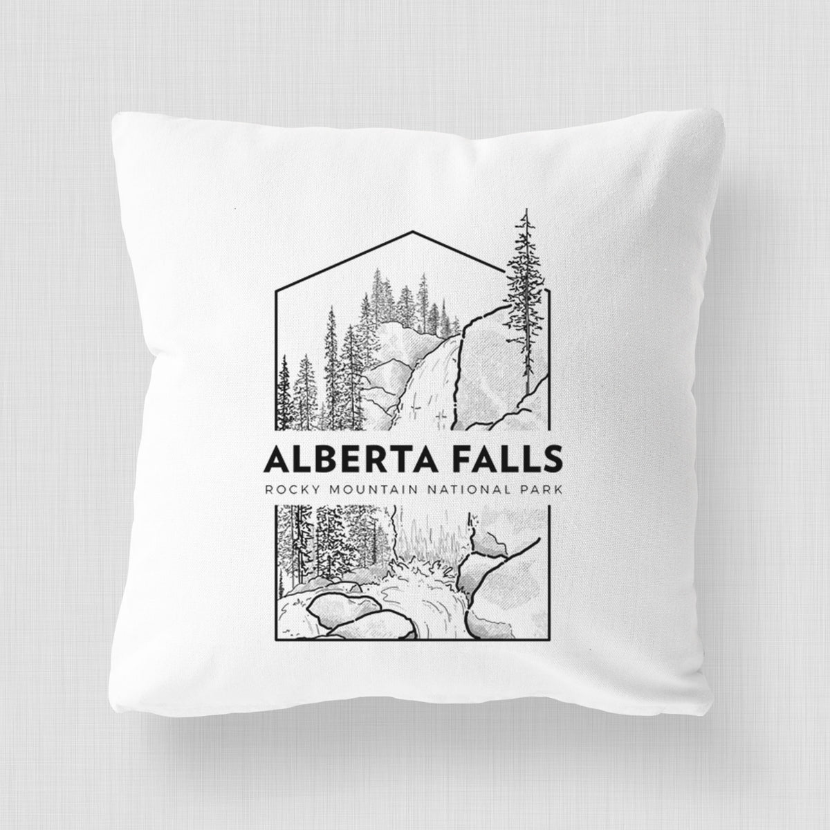 White pillow cover printed with a black line art badge of Alberta Falls with pine trees, with the words Alberta Falls, Rocky Mountain National Park.