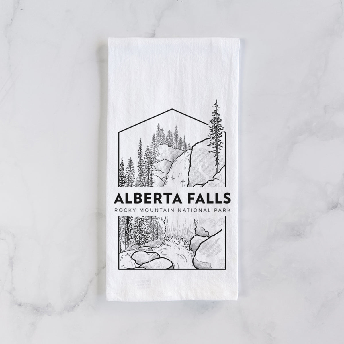 White cotton tea towel laid flat on marble, printed with a black line art badge of Alberta Falls with pine trees, with the words Alberta Falls, Rocky Mountain National Park.