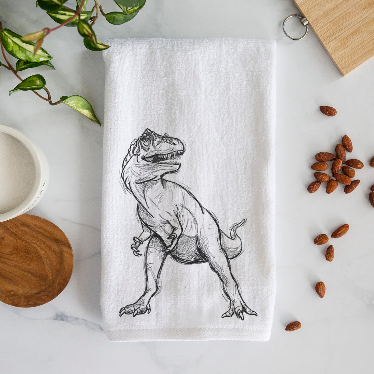 White hand towel printed with a black ink illustration of an Allosaurus walking.