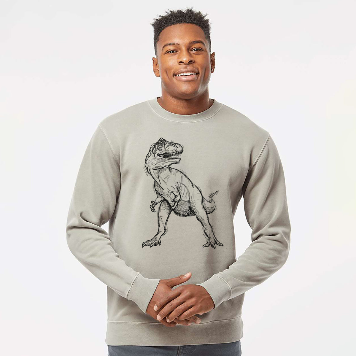 Model wearing a cement grey pigment dyed crewneck sweatshirt printed with a black ink illustration of an Allosaurus walking.