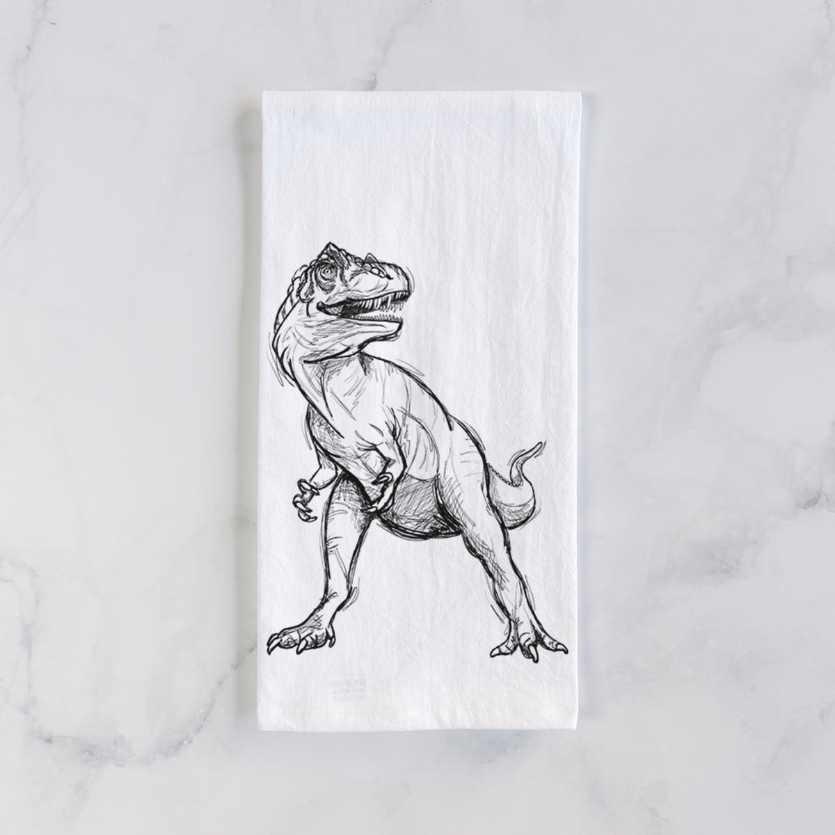 White cotton tea towel laid flat on marble, printed with a black ink illustration of an Allosaurus walking.