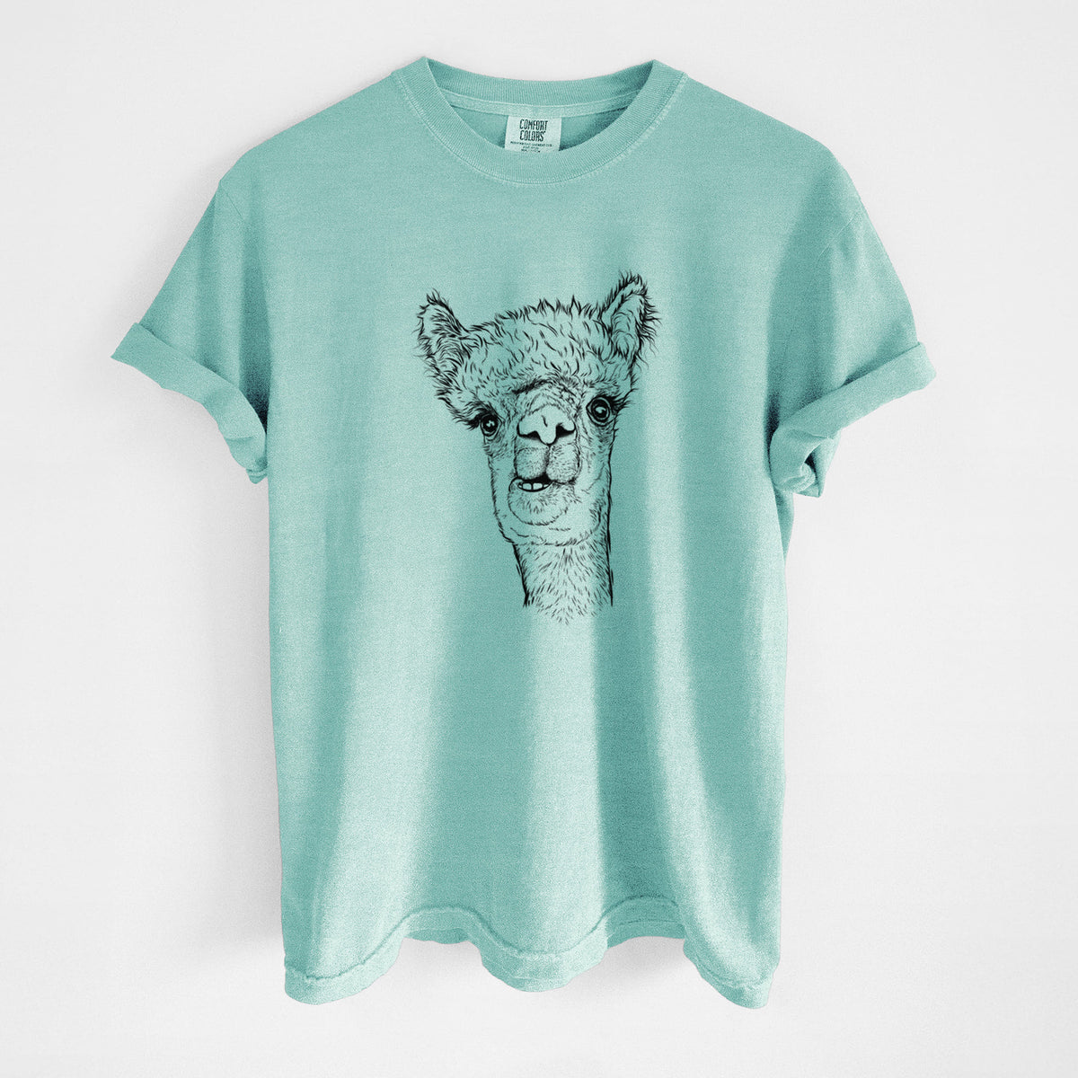 Chalky mint Comfort Colors t-shirt laid flat, printed with a detailed black ink portrait of a fluffy alpaca's head and neck.