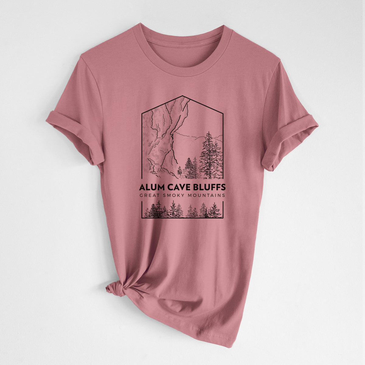 Mauve pink lightweight cotton t-shirt laid flat with the sleeves rolled, printed with a black line art badge of Alum Cave Bluffs with pine trees, with the words Alum Cave Bluffs, Great Smoky Mountains.