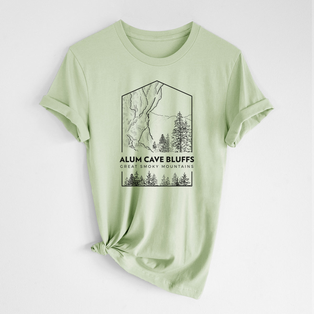 Spring green lightweight cotton t-shirt laid flat with the sleeves rolled, printed with a black line art badge of Alum Cave Bluffs with pine trees, with the words Alum Cave Bluffs, Great Smoky Mountains.