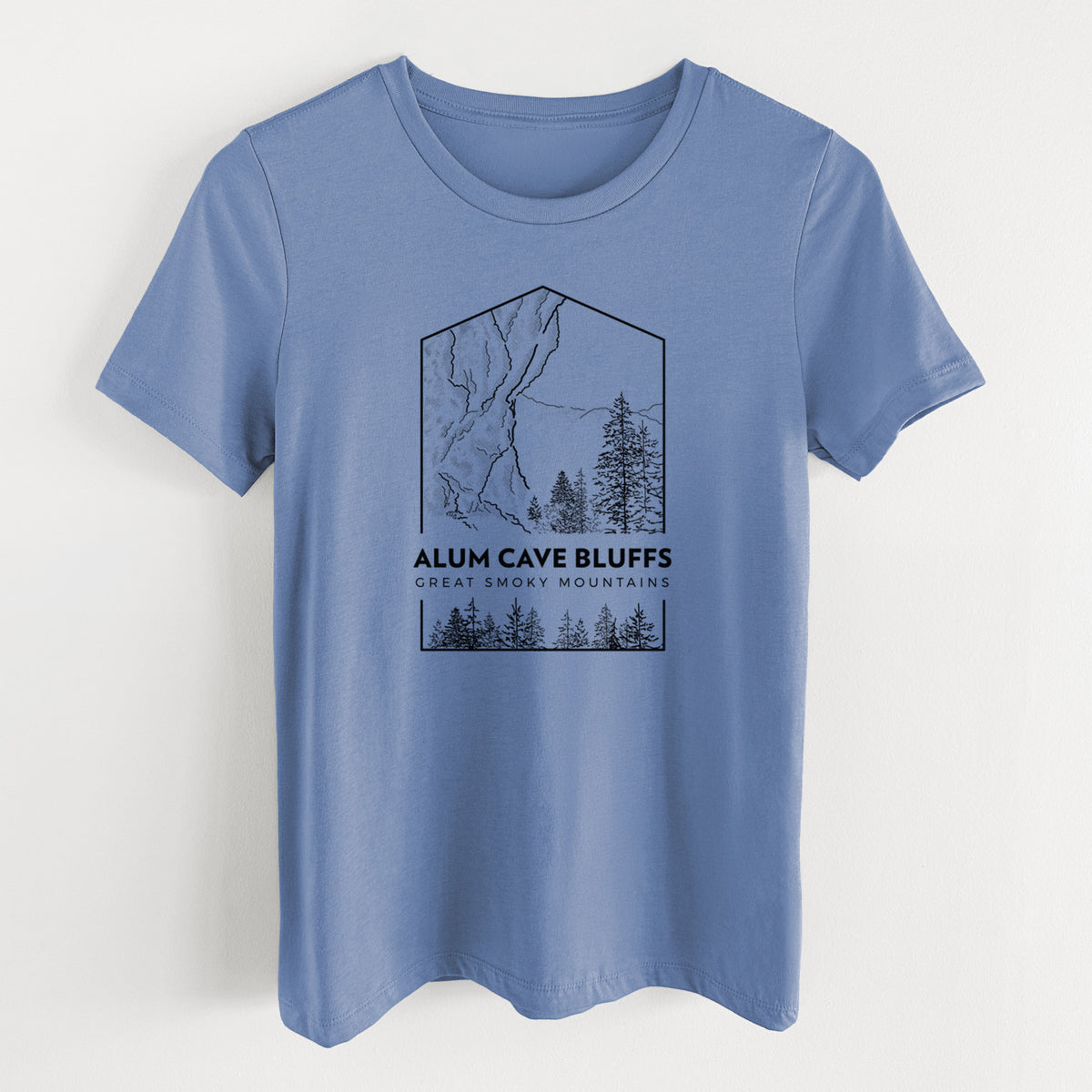 Blue bell women's relaxed fit cotton t-shirt laid flat, printed with a black line art badge of Alum Cave Bluffs with pine trees, with the words Alum Cave Bluffs, Great Smoky Mountains.