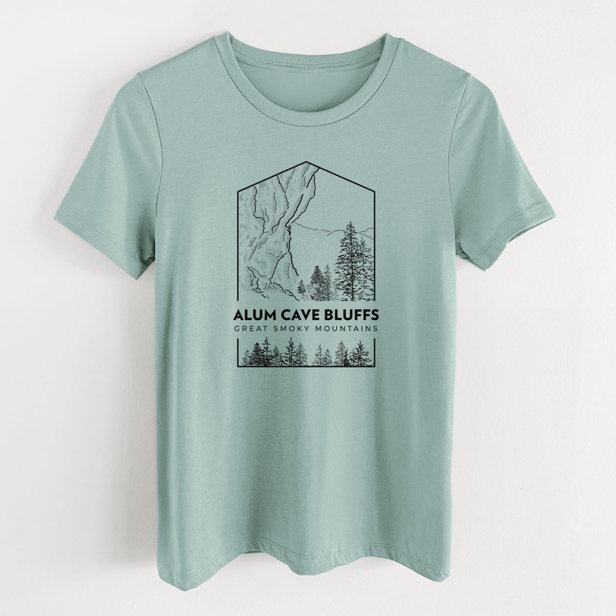 Dusty blue women's relaxed fit cotton t-shirt laid flat, printed with a black line art badge of Alum Cave Bluffs with pine trees, with the words Alum Cave Bluffs, Great Smoky Mountains.