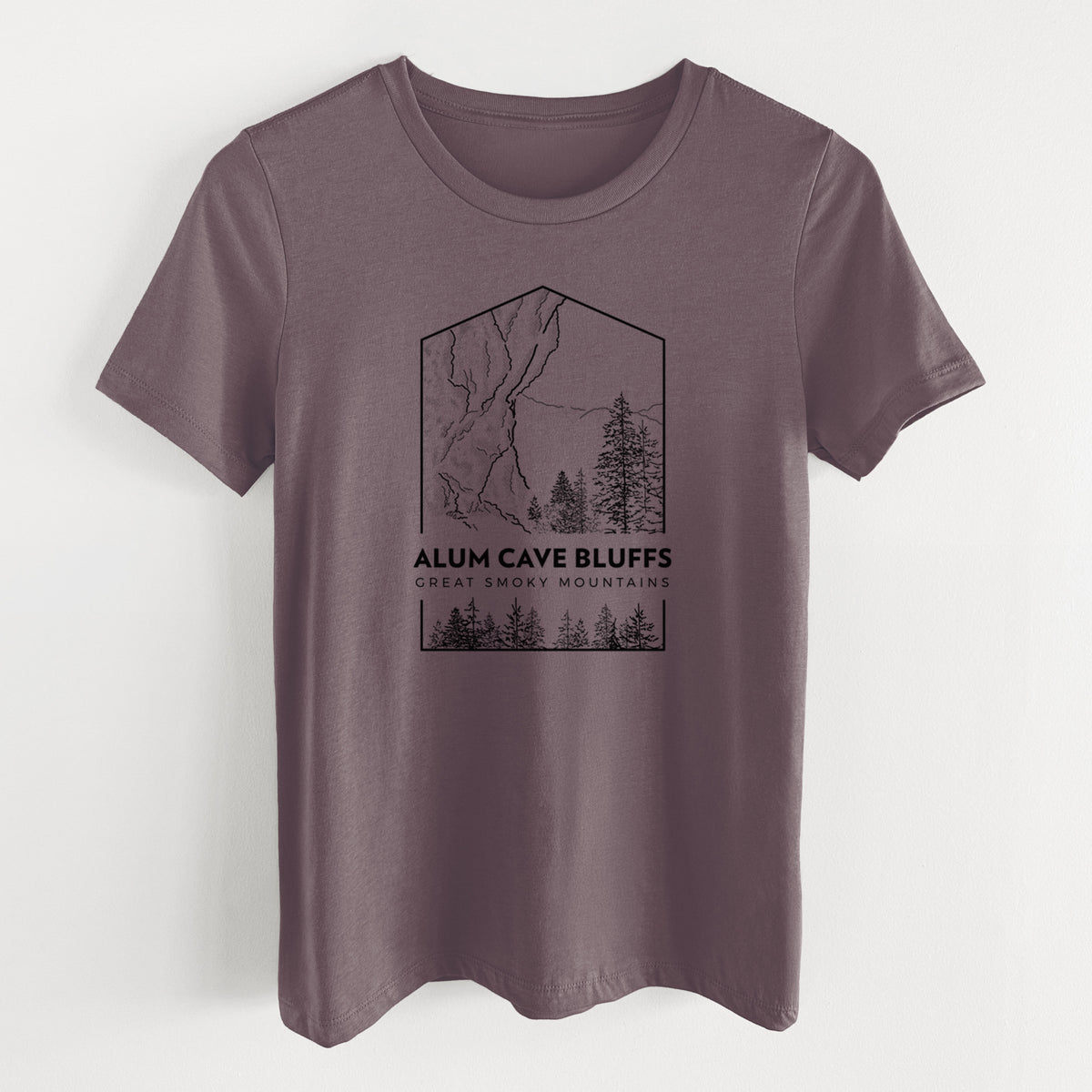Purple storm women's relaxed fit cotton t-shirt laid flat, printed with a black line art badge of Alum Cave Bluffs with pine trees, with the words Alum Cave Bluffs, Great Smoky Mountains.