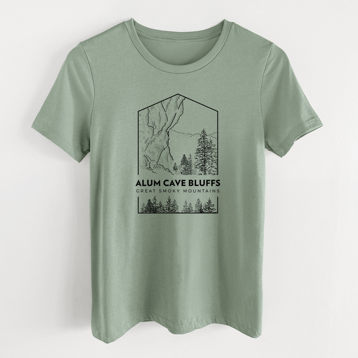 Sage green women's relaxed fit cotton t-shirt laid flat, printed with a black line art badge of Alum Cave Bluffs with pine trees, with the words Alum Cave Bluffs, Great Smoky Mountains.