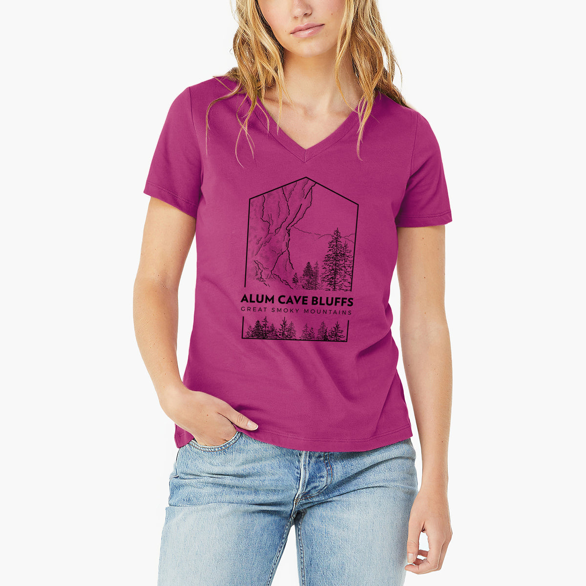 Woman wearing a berry pink women's relaxed fit cotton V-neck t-shirt printed with a black line art badge of Alum Cave Bluffs with pine trees, with the words Alum Cave Bluffs, Great Smoky Mountains.