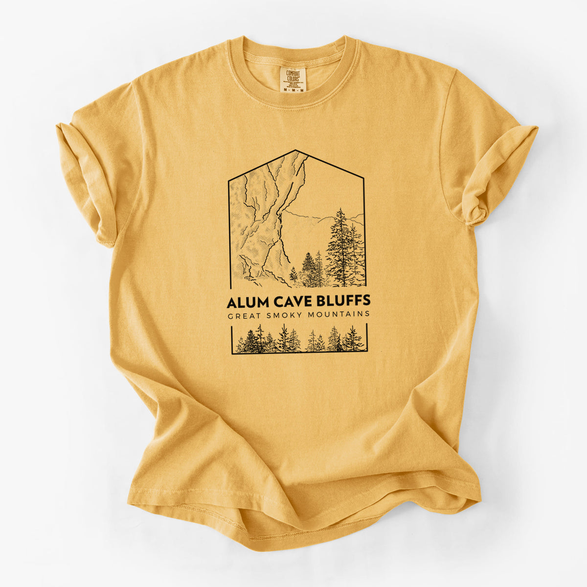 Golden wheat yellow Comfort Colors t-shirt laid flat, printed with a black line art badge of Alum Cave Bluffs with pine trees, with the words Alum Cave Bluffs, Great Smoky Mountains.