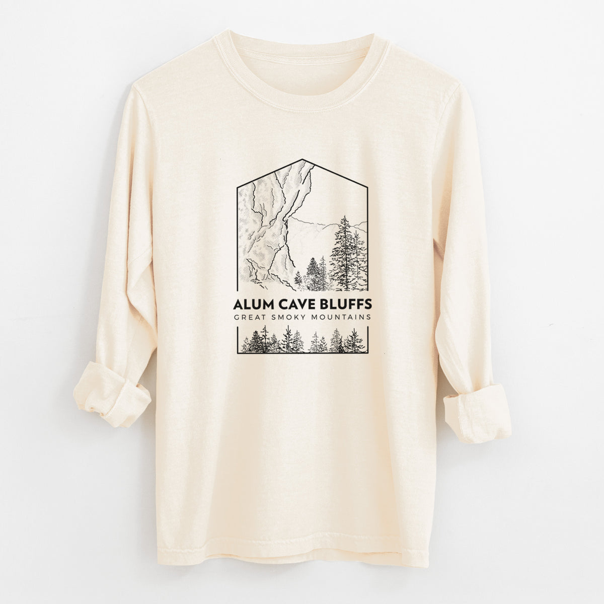 Ivory Comfort Colors long sleeve shirt laid flat with the cuffs rolled, printed with a black line art badge of Alum Cave Bluffs with pine trees, with the words Alum Cave Bluffs, Great Smoky Mountains.
