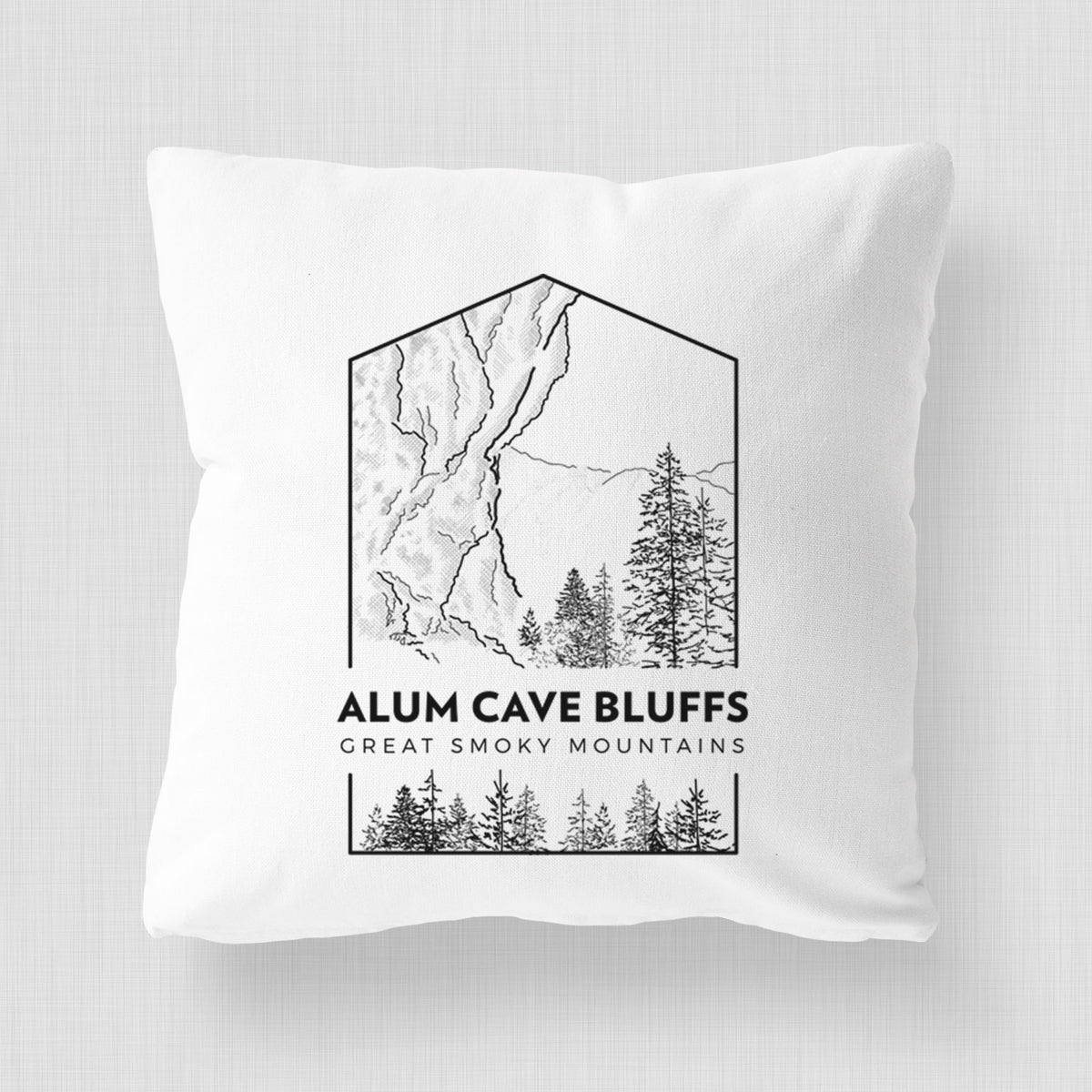 White pillow cover printed with a black line art badge of Alum Cave Bluffs with pine trees, with the words Alum Cave Bluffs, Great Smoky Mountains.