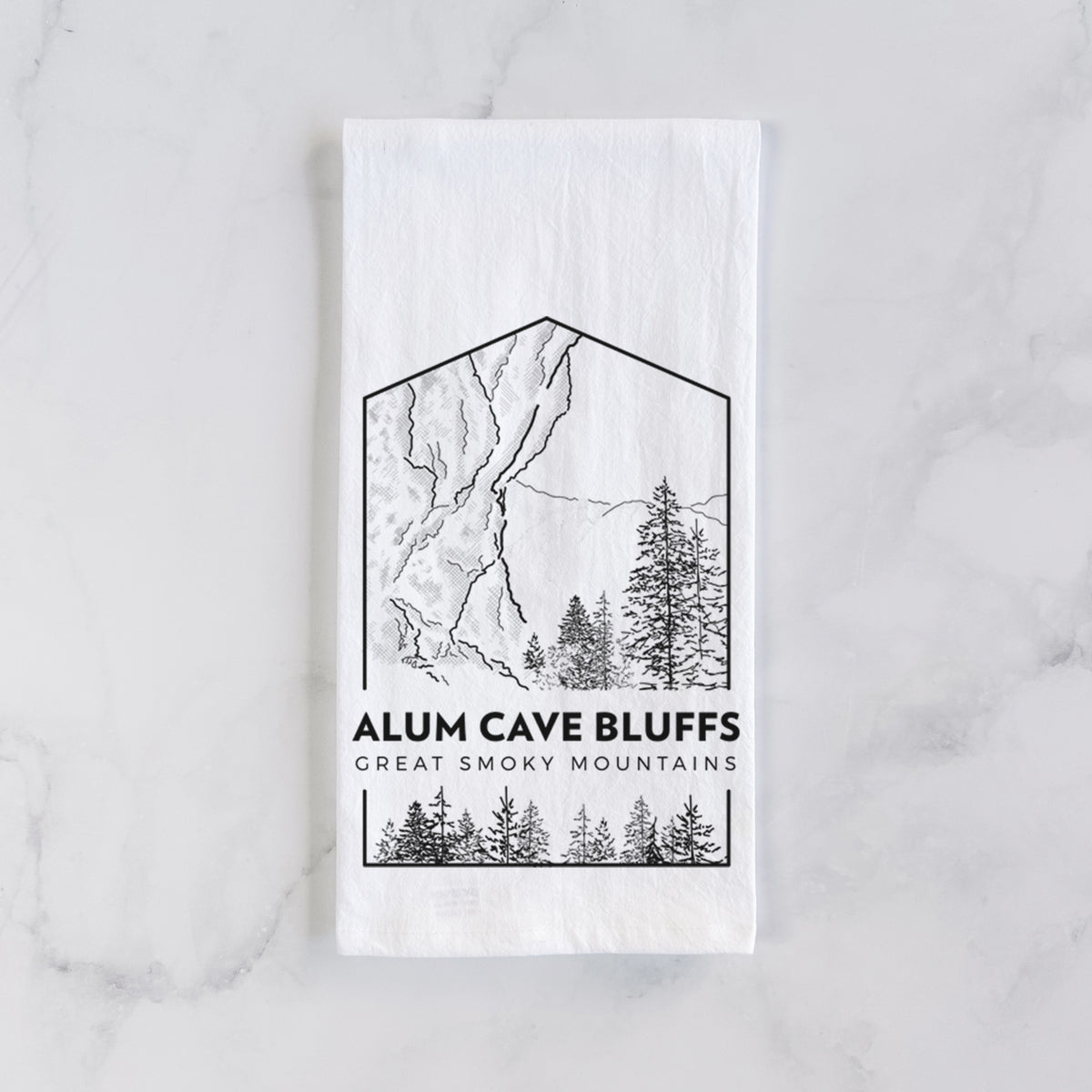 White cotton tea towel laid flat on marble, printed with a black line art badge of Alum Cave Bluffs with pine trees, with the words Alum Cave Bluffs, Great Smoky Mountains.