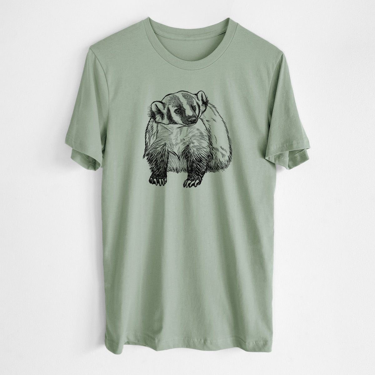 Sage green lightweight cotton t-shirt laid flat, printed with a detailed black ink illustration of an American badger facing forward.
