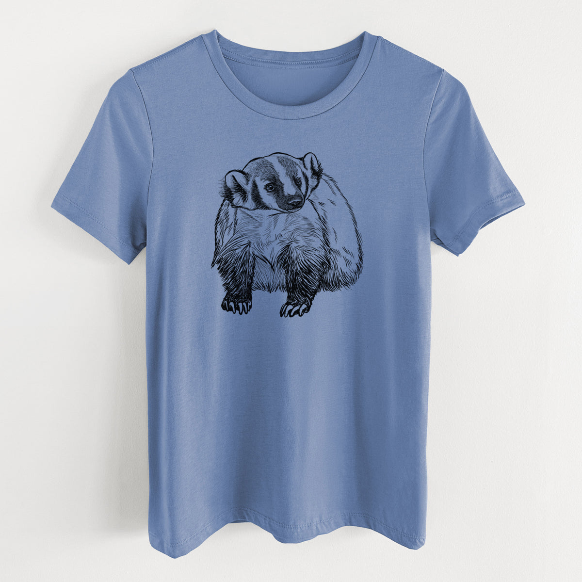 Blue bell women's relaxed fit cotton t-shirt laid flat, printed with a detailed black ink illustration of an American badger facing forward.