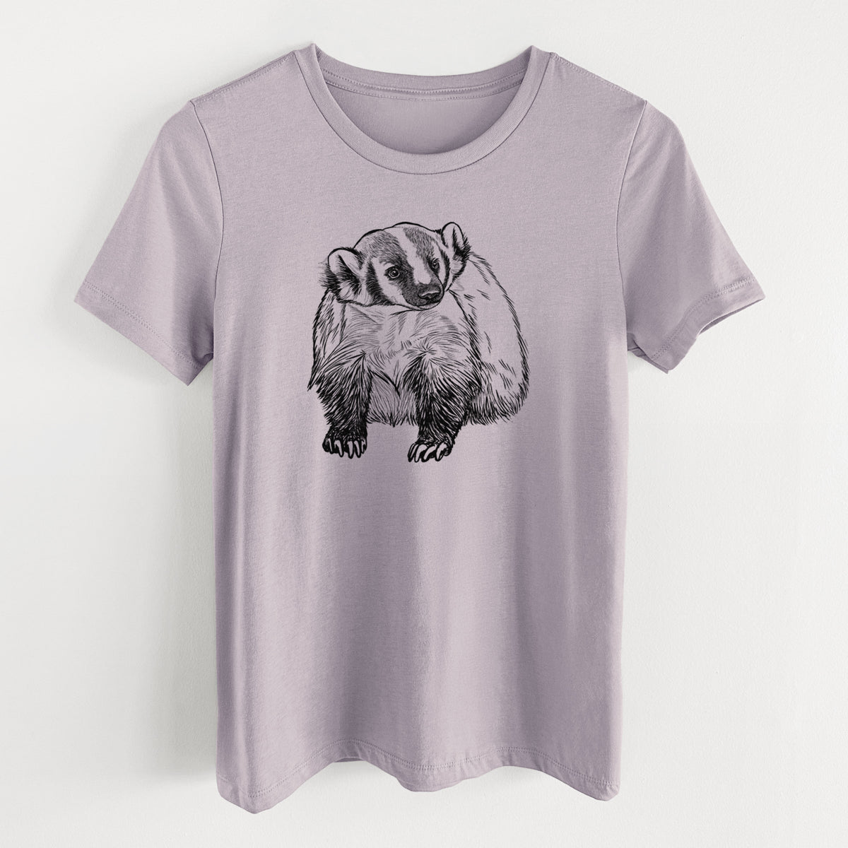 Light violet women's relaxed fit cotton t-shirt laid flat, printed with a detailed black ink illustration of an American badger facing forward.