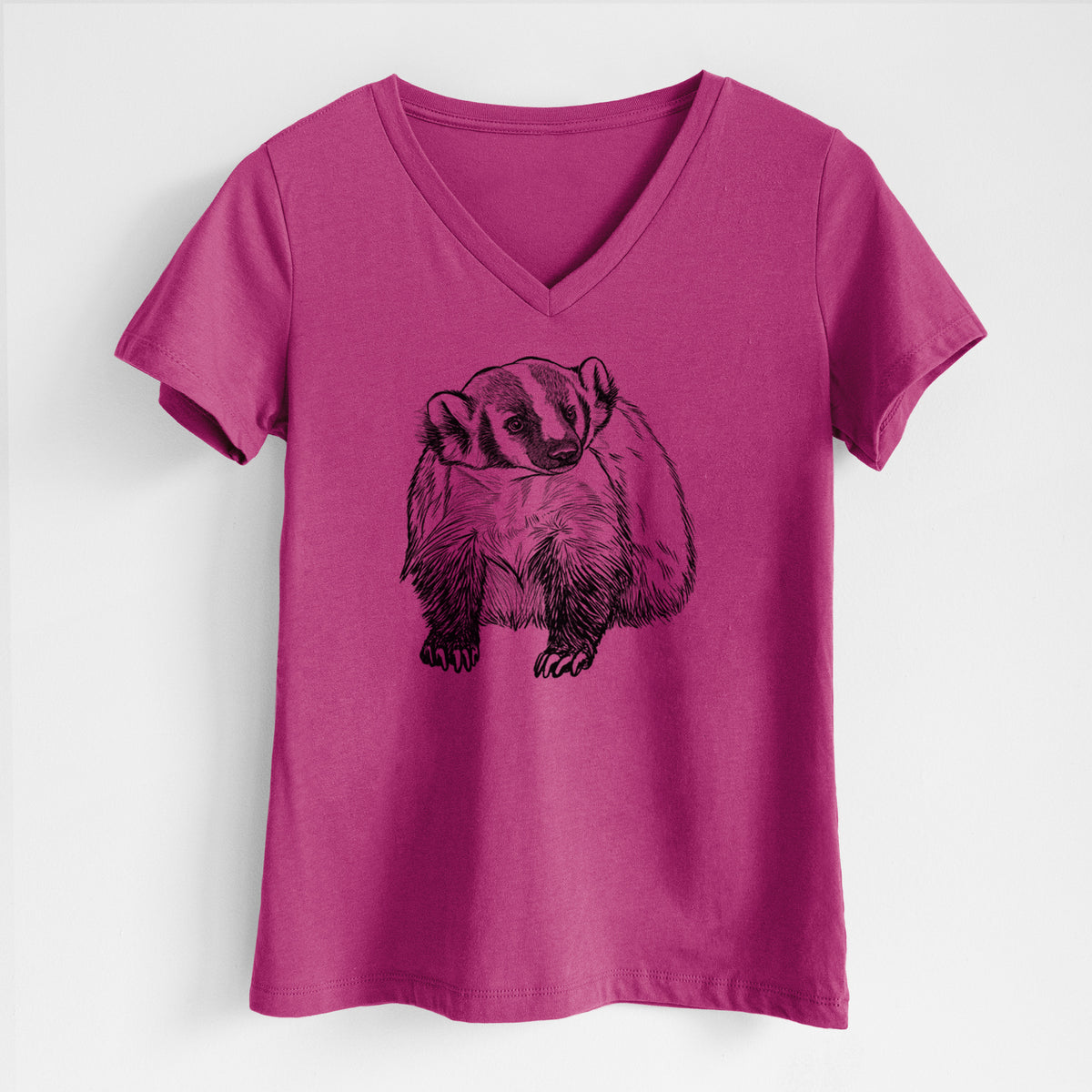 Berry pink women's relaxed fit cotton V-neck t-shirt laid flat, printed with a detailed black ink illustration of an American badger facing forward.