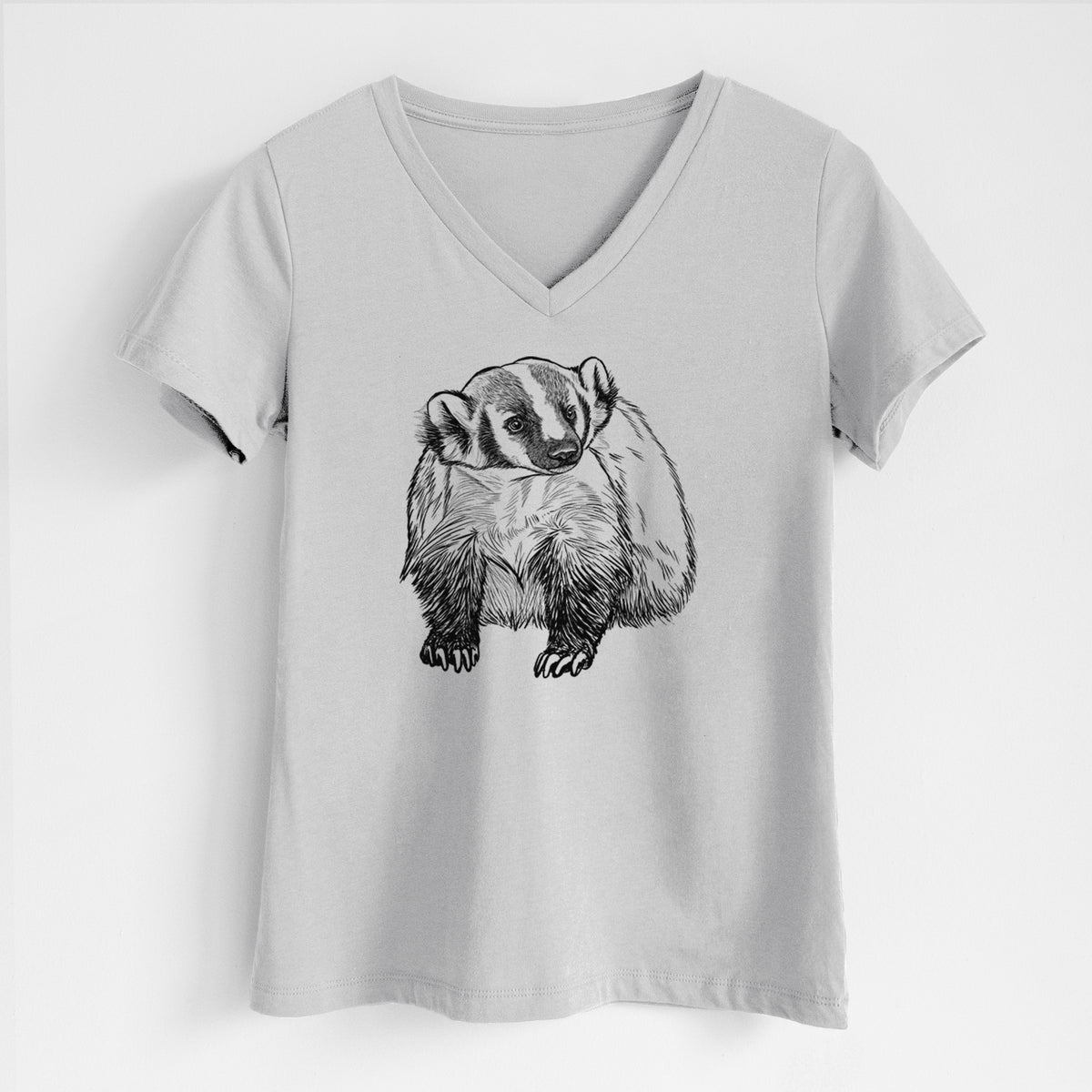 Lunar grey women's relaxed fit cotton V-neck t-shirt laid flat, printed with a detailed black ink illustration of an American badger facing forward.