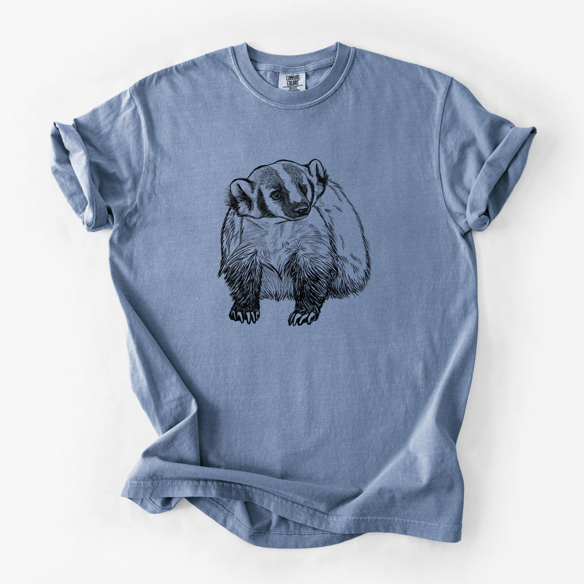 Blue jean Comfort Colors t-shirt laid flat, printed with a detailed black ink illustration of an American badger facing forward.