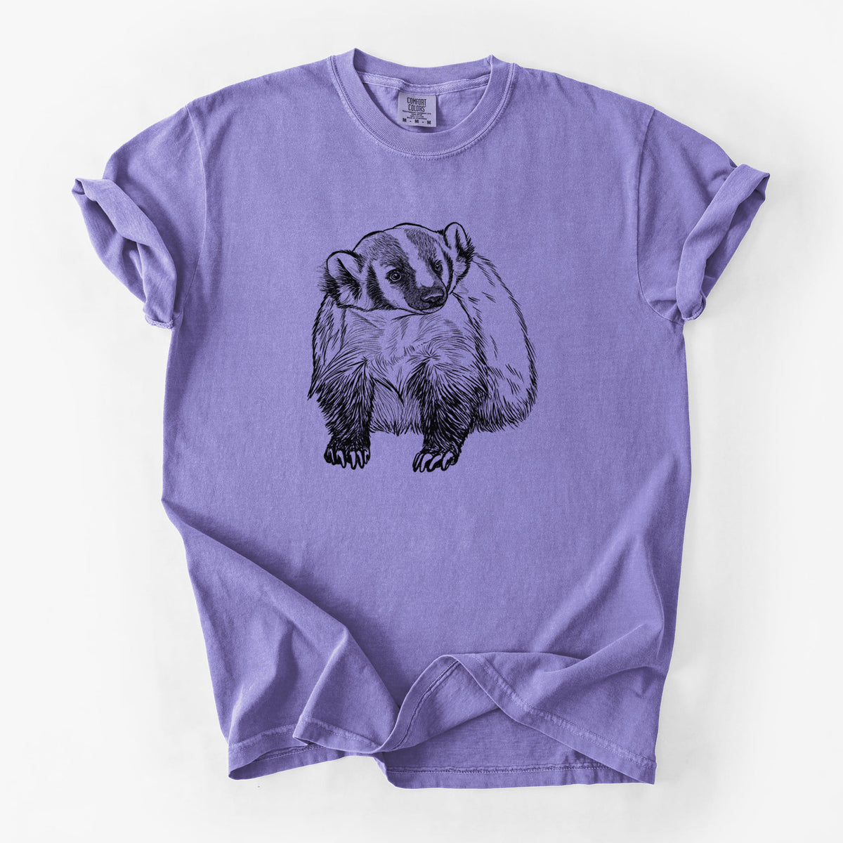 Violet purple Comfort Colors t-shirt laid flat, printed with a detailed black ink illustration of an American badger facing forward.