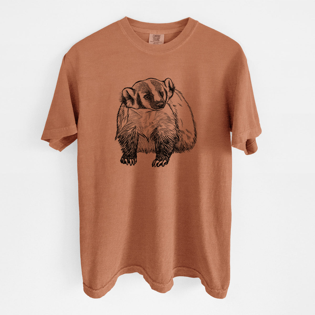 Yam burnt orange Comfort Colors t-shirt laid flat, printed with a detailed black ink illustration of an American badger facing forward.