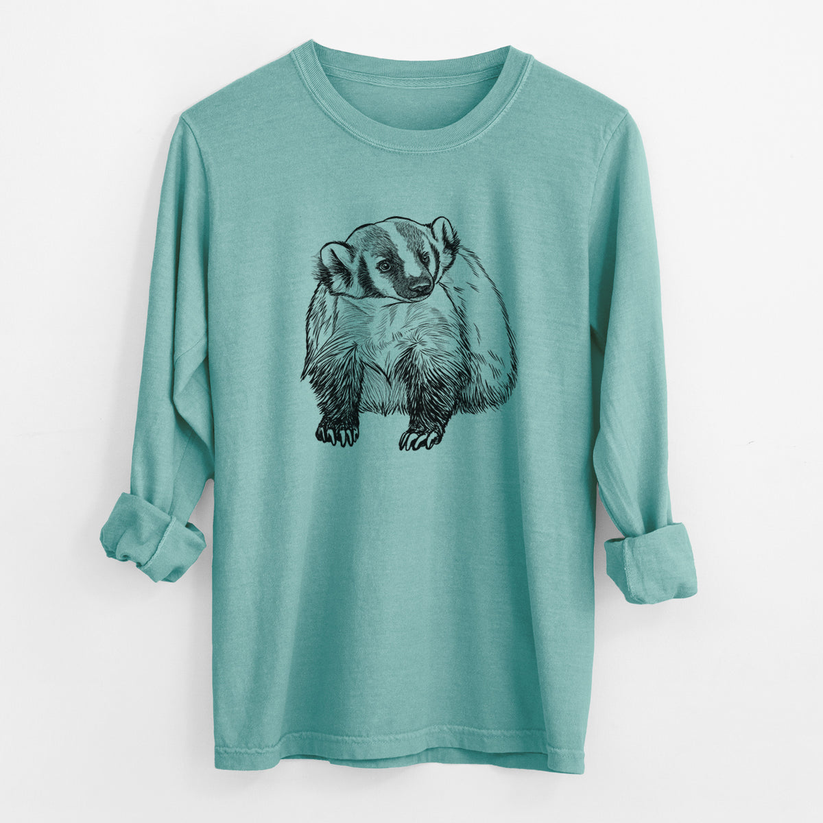 Reef green Comfort Colors long sleeve shirt laid flat with the cuffs rolled, printed with a detailed black ink illustration of an American badger facing forward.
