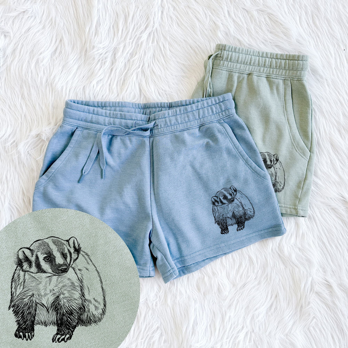 Two pairs of Cali Wave shorts in different colors printed with a detailed black ink illustration of an American badger facing forward, with a close-up of the print.